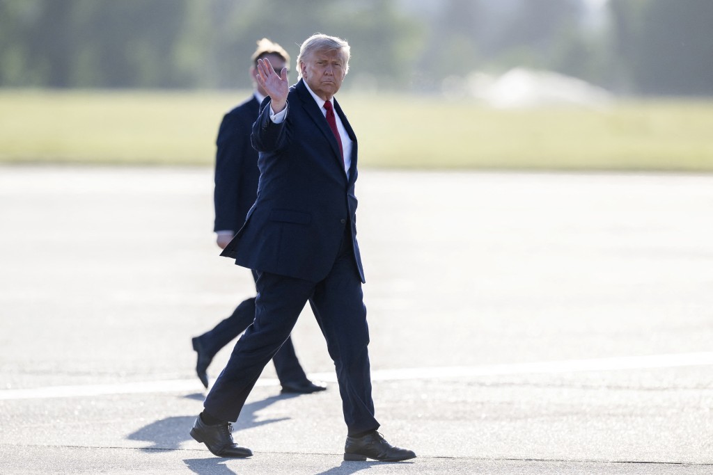US President Donald Trump gestures as he walks on the tarmas to board Air Force One at Geneva Airport en route to Versailles after attending the G7 summit, in Geneva on June 17, 2026. (Photo by MARTIAL TREZZINI / POOL / AFP)