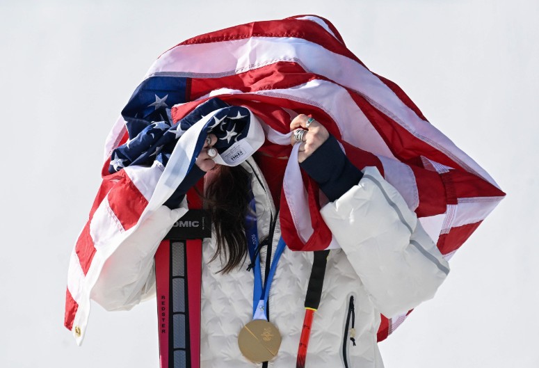 Breezy Johnson poses with her gold medal and the US flag on her head on the podium of the women's downhill event. AFP 