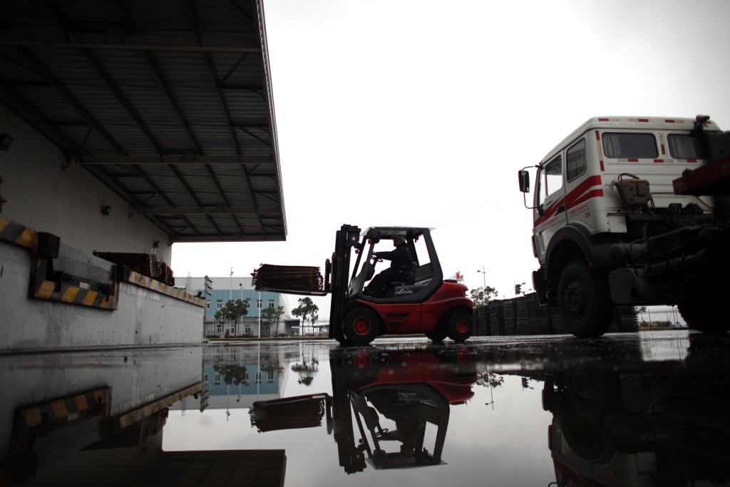 A worker loads copper cathodes into a warehouse near Yangshan Deep Water Port, south of Shanghai March 23, 2012. REUTERS