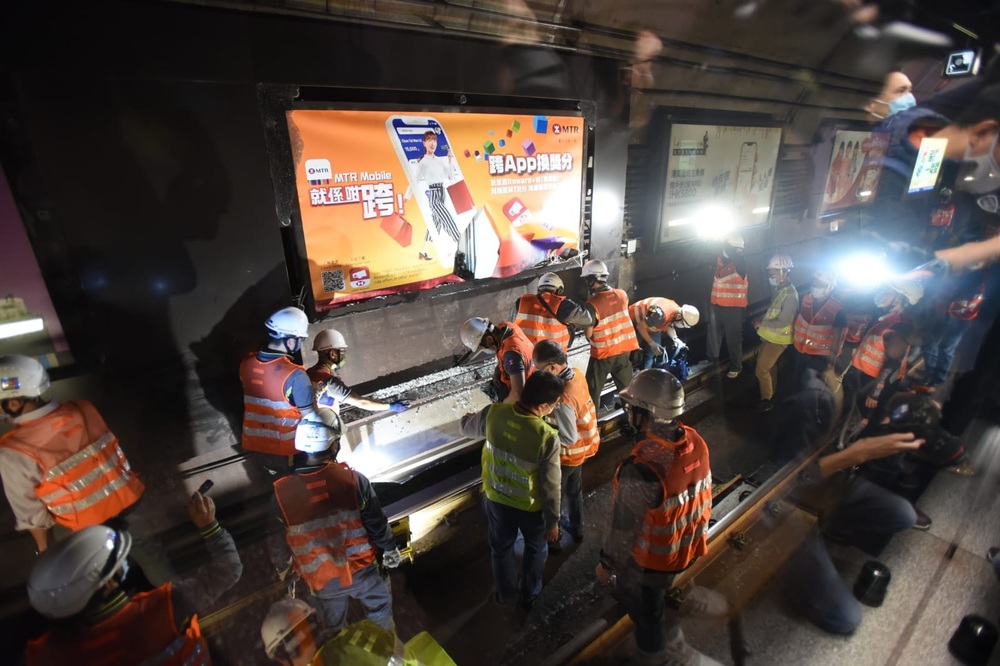 Workers pour onto the tracks after a door was torn from the carriage of a rush-hour train at Causeway Bay station. Above, stranded passengers queue for buses. Sing Tao Workers pour onto the tracks after a door was torn from the carriage of a rush-hour train at Causeway Bay station. Above, stranded passengers queue for buses. Sing Tao