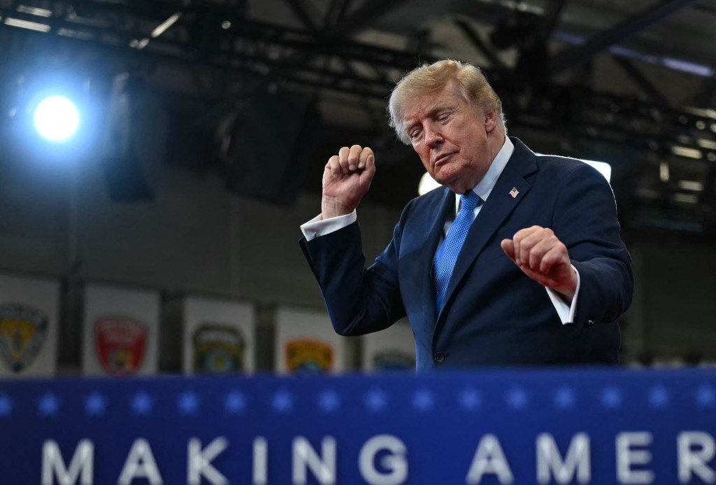 US President Donald Trump dances as he departs after delivering remarks at the Nassau County Police Academy Center for Training and Intelligence in Garden City, New York, on August 14, 2026. (Photo by Kent NISHIMURA / AFP)