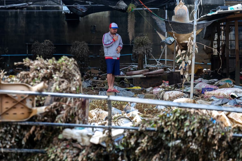 A man stands amid debris in a flooded area in Hat Yai district, Songkhla province, Thailand, November 28, 2025. REUTERS/Athit Perawongmetha 
