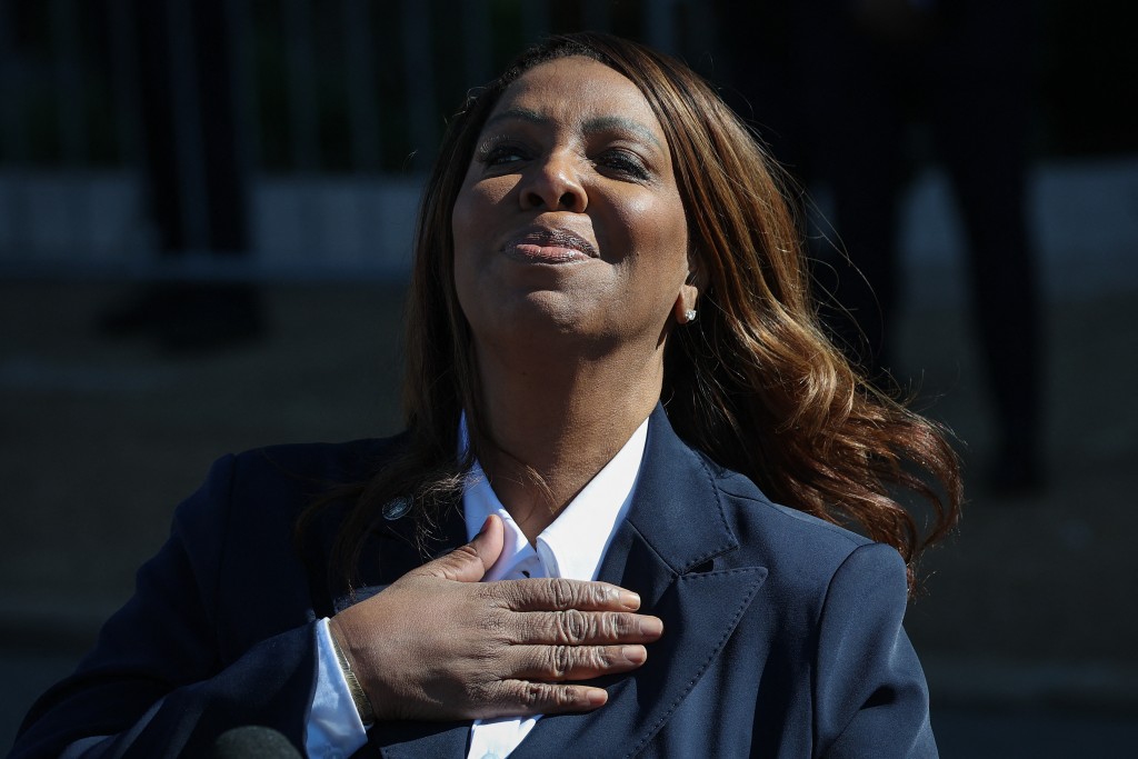 Photo by WIN MCNAMEE / GETTY IMAGES NORTH AMERICA / GETTY IMAGES VIA AFP. New York Attorney General Letitia James places her hand over her heart to acknowledge supporters while speaking outside the Walter E. Hoffman United States Courthouse following an arraignment hearing on October 24, 2025 in Norfolk, Virginia.