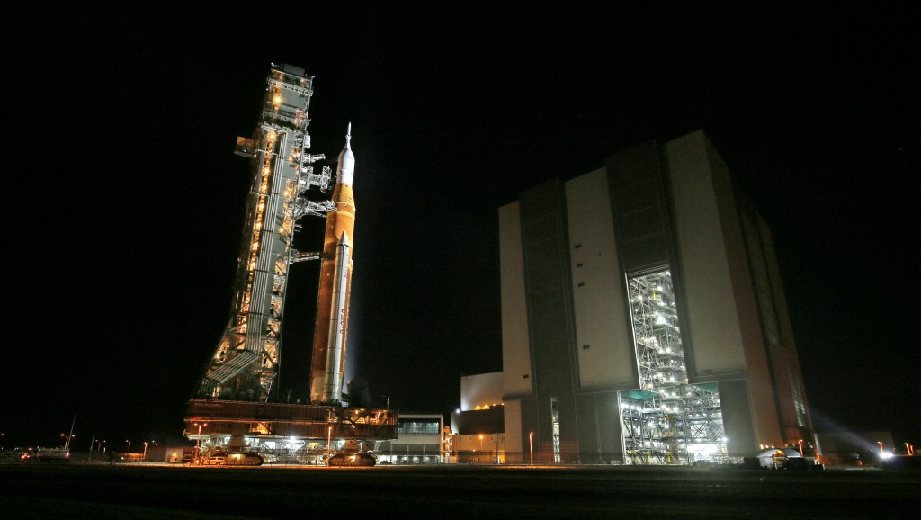 Photo by GREGG NEWTON / AFP  Mobile launcher 1 containing the massive Artemis II Space Launch System (SLS) rocket and Orion spacecraft rolls out from the Vehicle Assembly Building to Launch Pad 39B at the Kennedy Space Center in Cape Canaveral, Florida on March 20, 2026.