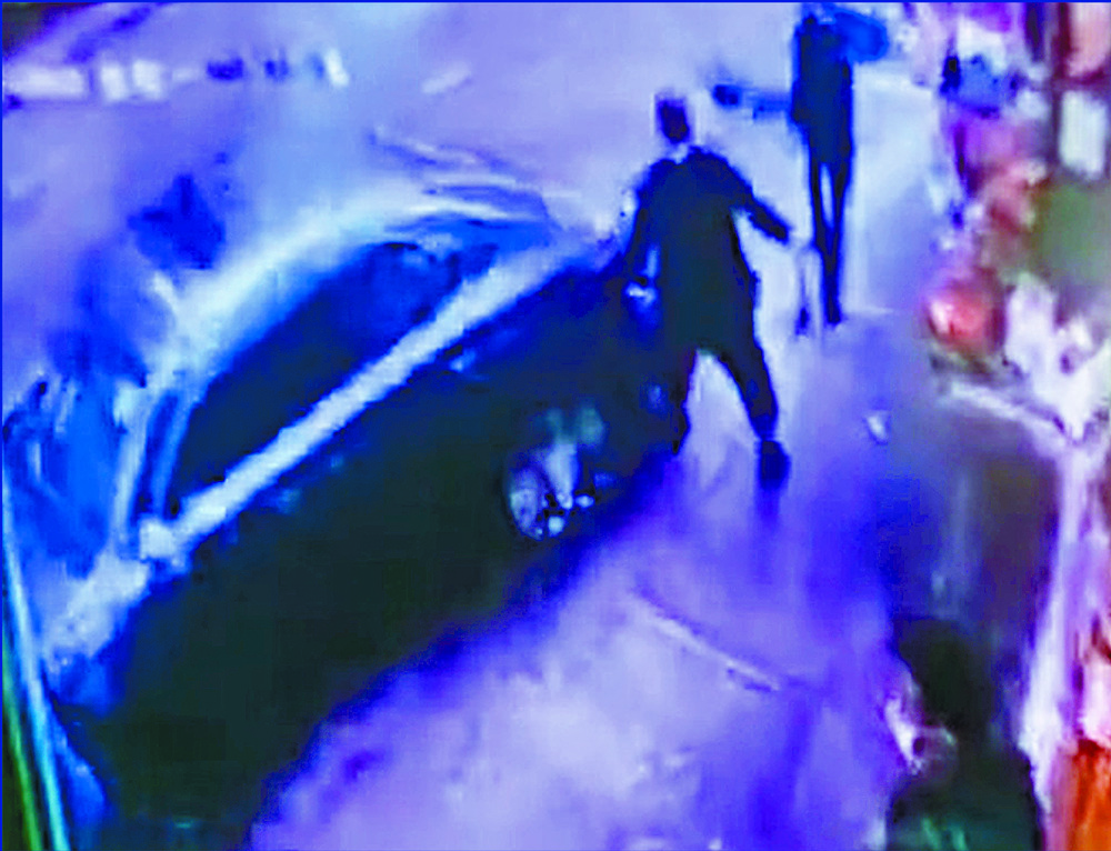 Video grabs show the Lexus sedan backing into pedestrians and goods. One of the injured makes a call. SING TAO