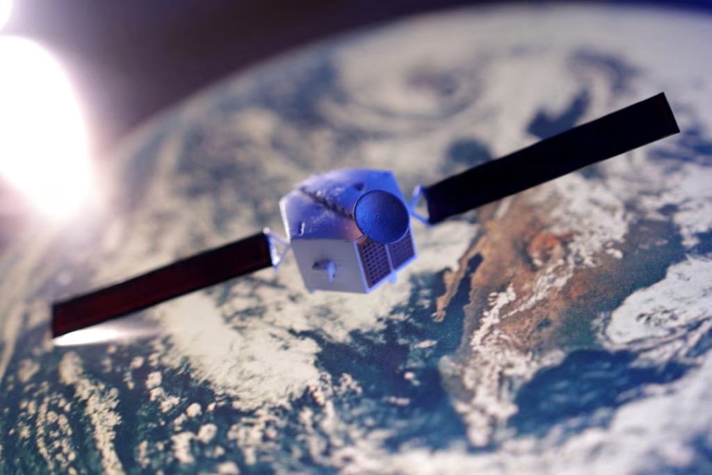 A satellite model is placed on a picture of Earth in this illustration taken November 25, 2024. REUTERS/Dado Ruvic/Illustration/File Photo
