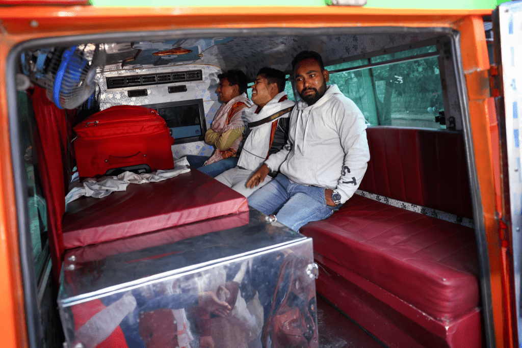 Relatives of Dinesh Misra, who died in a deadly explosion near the historic Red Fort in the old quarters of Delhi, sit inside an ambulance carrying Misra's body, outside a mortuary at a hospital, in Delhi, India, November 11, 2025. REUTERS/Anushree Fadnavis