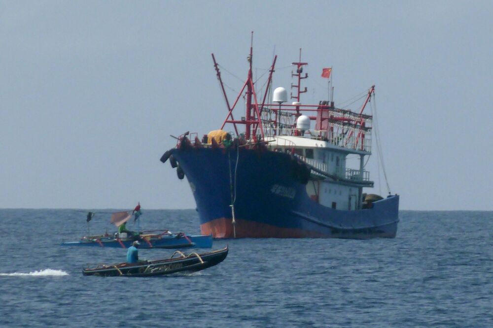 This photo taken on February 6, 2023, shows Filipino fishermen aboard their boats sailing past a Chinese vessel in the Scarborough Shoal, in the disputed South China Sea. (AFP) This photo taken on February 6, 2023, shows Filipino fishermen aboard their boats sailing past a Chinese vessel in the Scarborough Shoal, in the disputed South China Sea. (AFP)