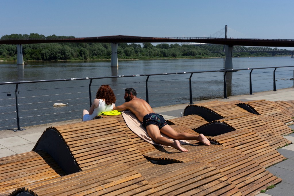A man sunbathes on the bank of the Vistula River during a heatwave in Warsaw, Poland, (Reuters)