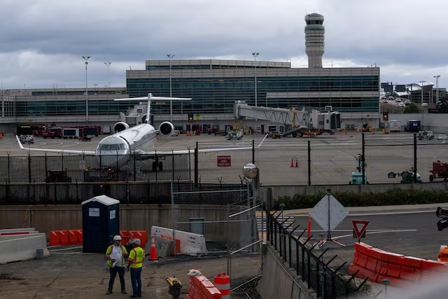 Construction crews work near the air traffic control tower at Reagan Washington National Airport as the U.S. government shutdown continues in Arlington, Virginia, U.S., October 8, 2025. REUTERS/Nathan Howard 