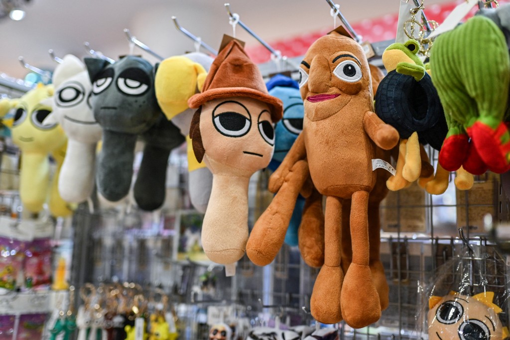 A small brown soft toy of the best-known Indonesian Brainrot character "Tung Tung Tung Sahur" (R), which resembles a long drum called a "kentongan", displayed for sale at a shop in central Tokyo. (AFP)