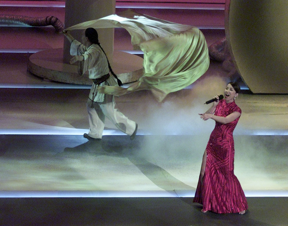 Coco Lee performs at the Oscars in a red chongsam and, inset, her funeral portrait. Coco Lee performs at the Oscars in a red chongsam and, inset, her funeral portrait.
