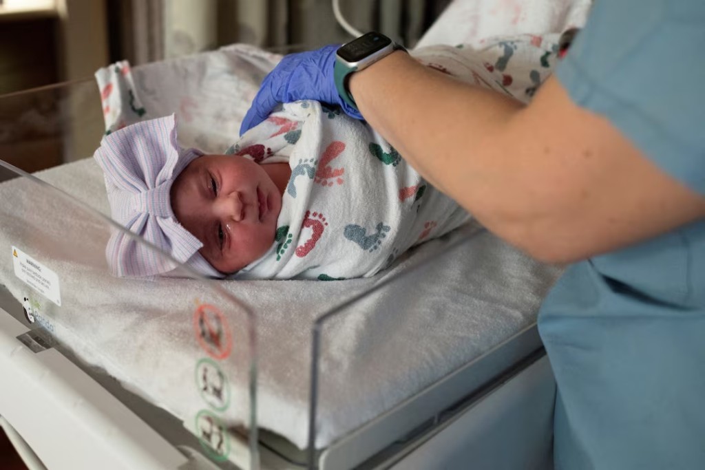 A nurse checks the vitals of a newborn baby in the Family Birth Center at Beaumont Hospital in Royal Oak, Michigan, U.S., February 1, 2022. REUTERS/Emily Elconin/File Photo