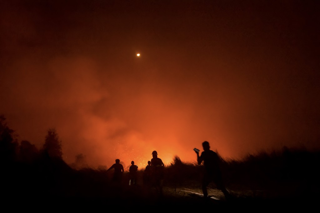 Photo by MUDA SAGALA / AFP  Local residents and volunteers of the local fire brigade battle a peatland fire at Gambut village in Banjar, South Kalimantan on October 2, 2026.