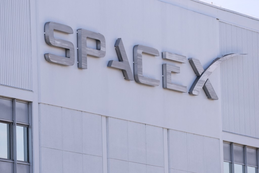 Photo by PATRICK T. FALLON / AFP  SpaceX signage displayed outside a Space Exploration Technologies Corp. facility in Hawthorne, California on March 26, 2026.