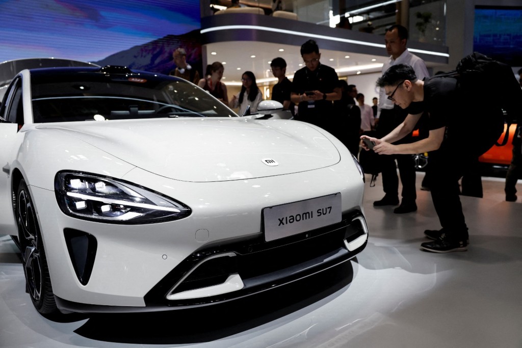Visitors look at a Xiaomi SU7 electric vehicle. Reuters