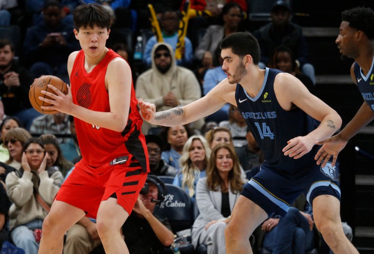Yang Hansen keeps the ball away from Memphis Grizzlies center Zach Edey. REUTERS