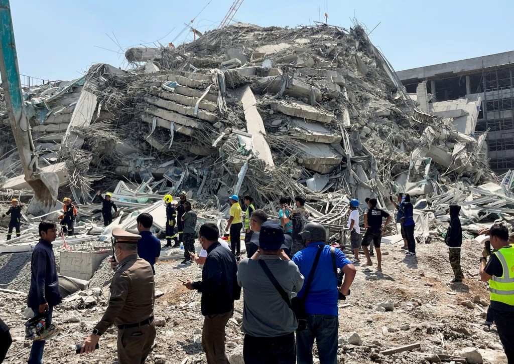 People stand near the site of a collapsed building after a strong earthquake in Bangkok, Thailand, March 28. (Reuters)