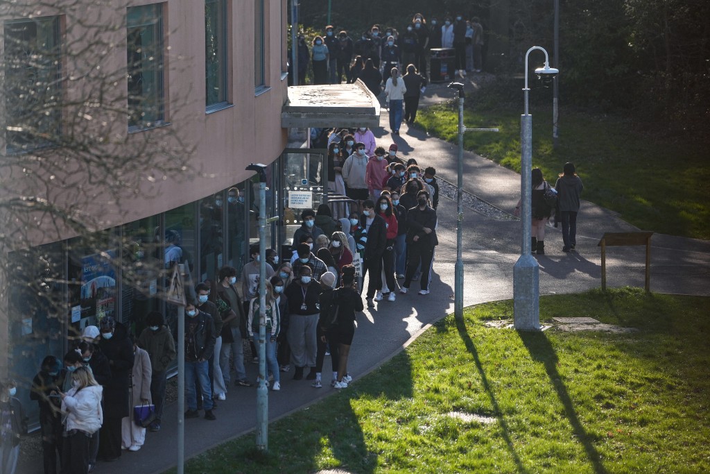 Students wearing face masks queue up to get vaccinated at the University of Kent in Canterbury, south-east England on March 18, 2026, following an outbreak of meningitis. (Reuters)