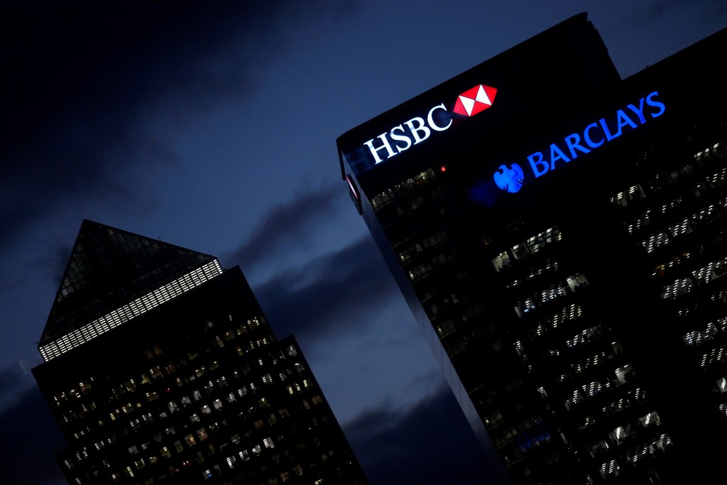 HSBC and Barclay's buildings are lit up at dusk in the Canary Wharf financial district of London, Britain, November 19, 2018. REUTERS
