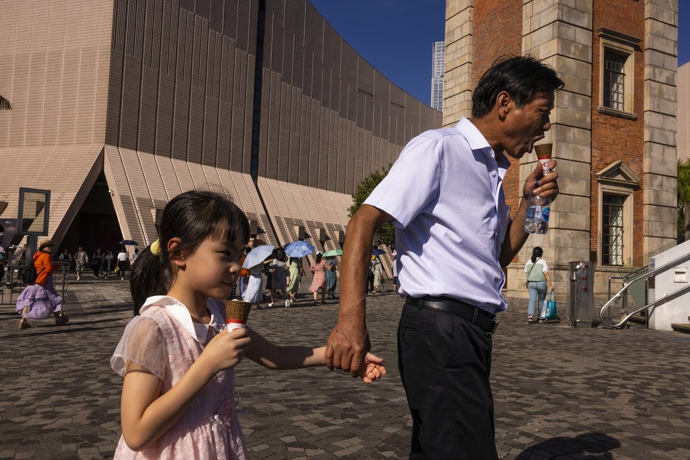 Tourists, from mainland China, eat ice cream amid the summer heat in Hong Kong, Thursday, Aug. 3, 2023. (AP)