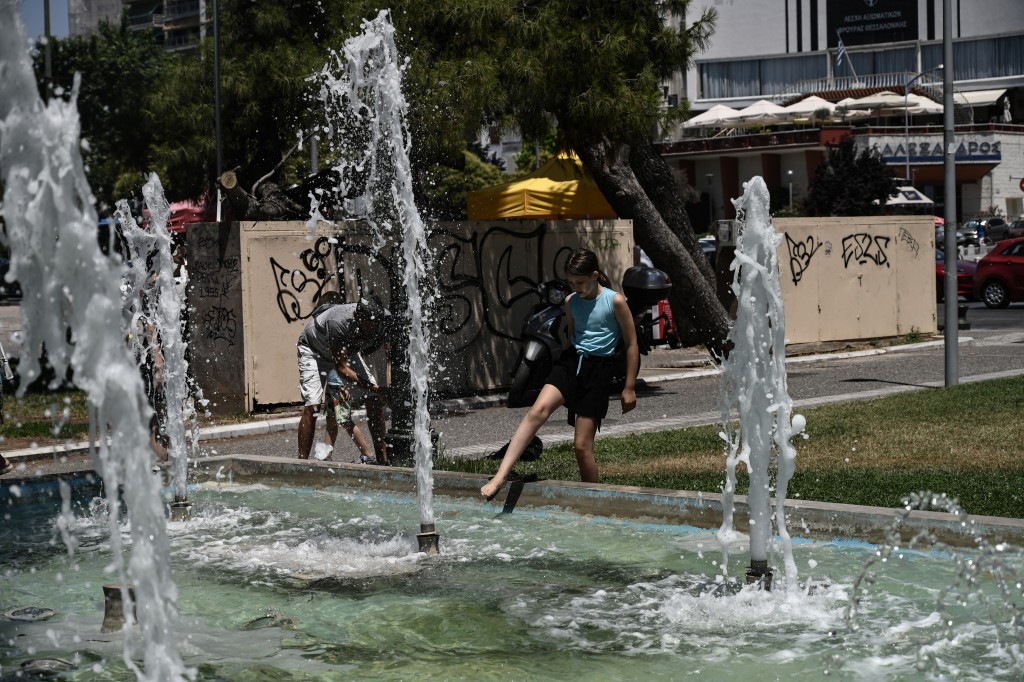 A girl cools down at a public fountain during a heatwave in Thessaloniki, Greece on July 8, 2025. (AFP)
