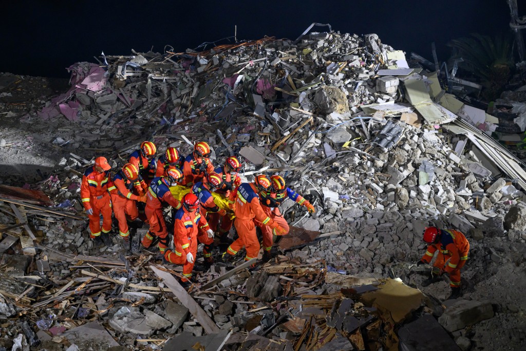 Photo by - / CNS / AFP Rescue workers recover a victim at the site of a landslide in Pengshui County in Chongqing, China on July 17, 2026.