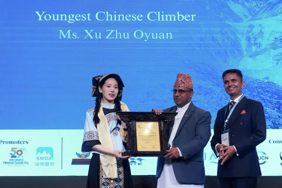 Xu Zhu Oyuan, the youngest Chinese climber to summit Mount Everest, receives an honorary certificate from Badri Prasad Pandey, Nepal's Minister for Culture, Tourism, and Civil Aviation, during the Everest Summiteers Summit in Kathmandu, Nepal, on Tuesday, May 27, 2025. Show Less Niranjan Shrestha/AP