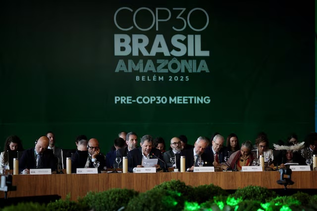 Brazil's Finance Minister Fernando Haddad speaks next to Simon Stiell, Executive Secretary of UN Climate Change (UNFCCC), and Brazil's COP30 President Andre Correa do Lago during the ministerial preparatory meeting (Pre-COP30), ahead of the COP30 Climate Summit, in Brasilia, Brazil October 13, 2025. REUTERS/Mateus Bonomi/File Photo 