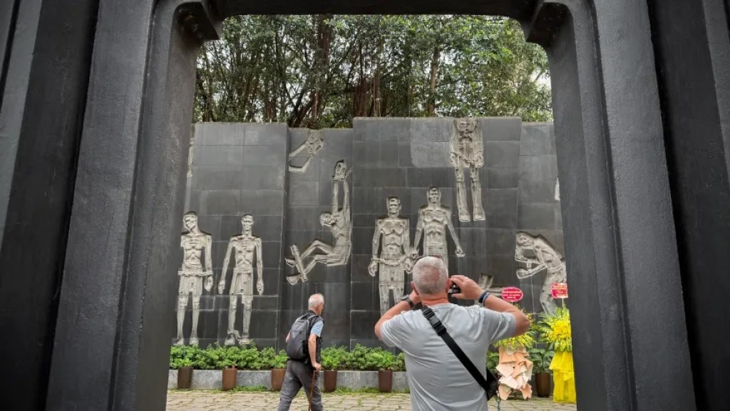 A tourist takes photos of a mural at the Hoa Lo prison museum in Hanoi, Vietnam, March 26, 2025. (AP Photo/Hau Dinh)