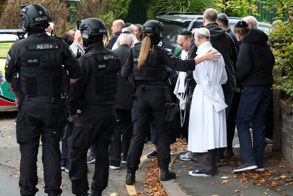 People gather near the scene, after a report of an incident in which a car was driven at pedestrians and a stabbing attack, near a synagogue in north Manchester, Britain, October 2, 2025. (Reuters)