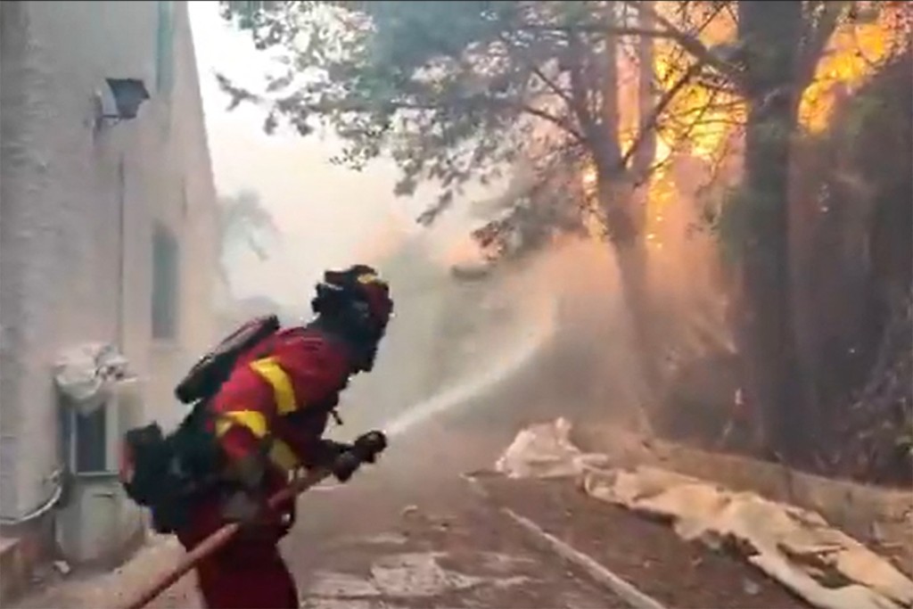Photo by HANDOUT / X ACCOUNT OF SPAIN'S MILITARY EMERGENCIES UNIT UME (@UMEGOB) / AFP  This screengrab from a video posted on the X account of Spain's Military Emergencies Unit UME (@UMEgob) on July 23, 2026, shows UME personnel fighting a wildfire in San Martín de Valdeiglesias, Madrid.