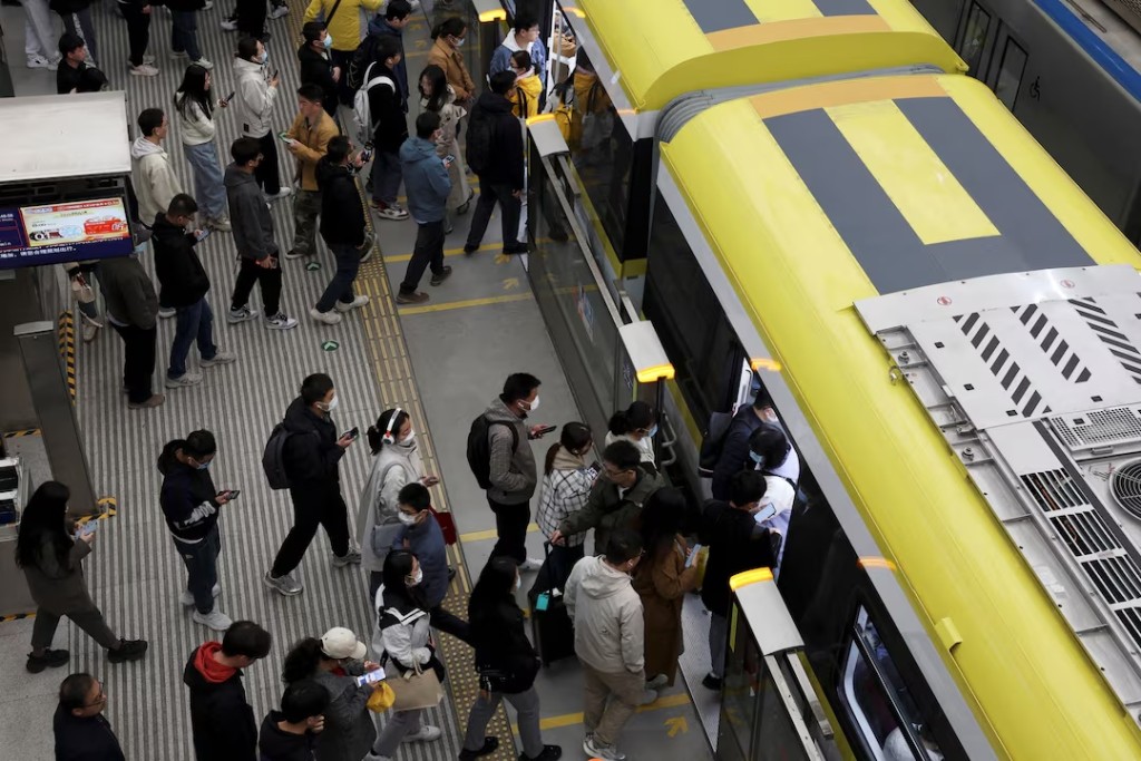 Commuters line up to board a train at a subway station near the Zhongguancun tech hub, during morning rush hour in Beijing, China March 27, 2025. REUTERS/Florence Lo/File Photo 