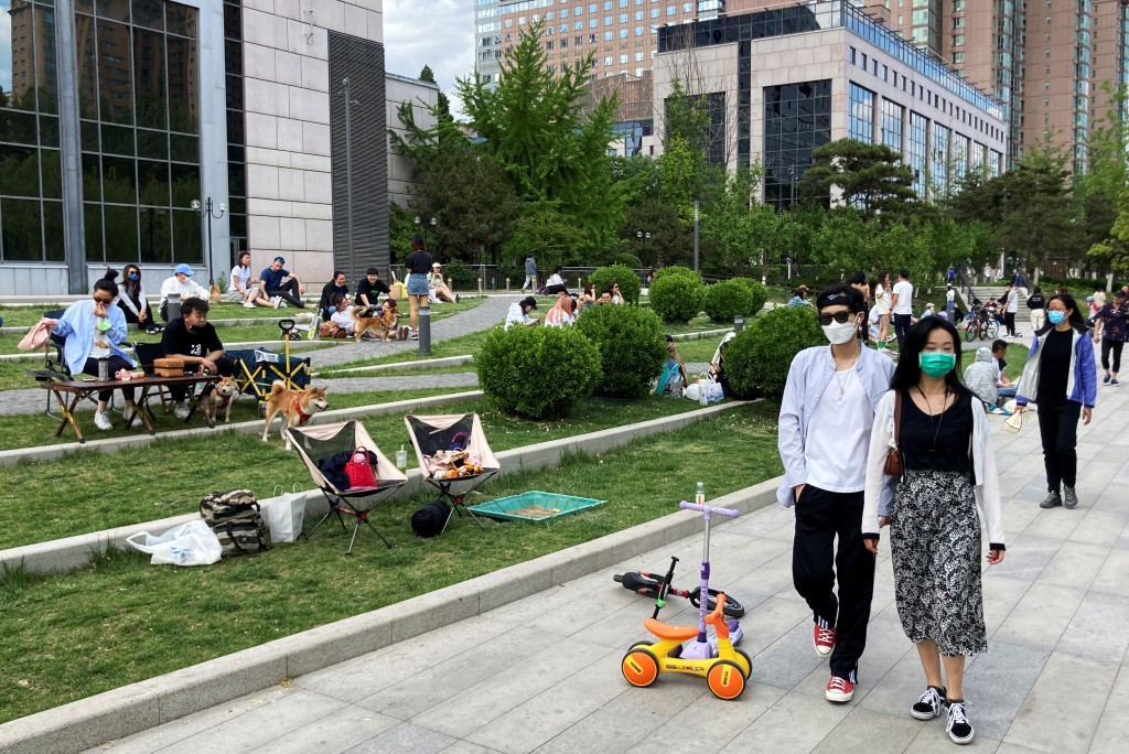 People sit at an outdoor area after the government banned restaurant dining during the Labour Day holiday, to prevent the spread of the coronavirus disease (COVID-19) amid the outbreak, in Chaoyang district of Beijing, China May 1, 2022. REUTERS