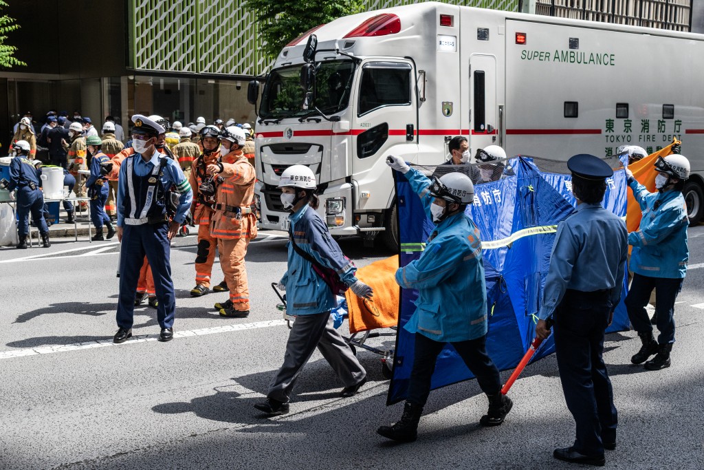A person is taken on a stretcher to an ambulance by paramedics at the Ginza 6 Shopping Center in Tokyo on May 25, 2026, after an individual allegedly sprayed a substance in the area. (AFP)