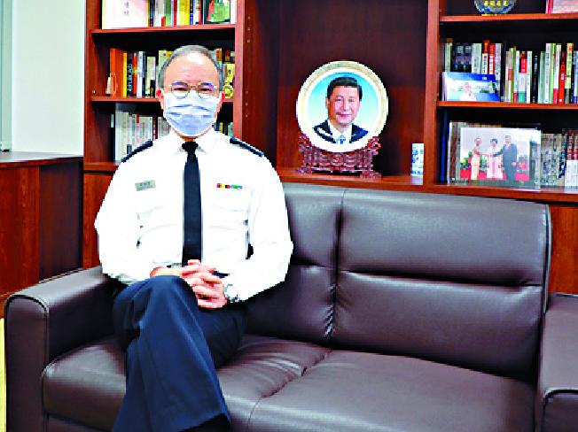 Erick Tsang sits proudly in his office in front of a picture of Xi Jinping. Erick Tsang sits proudly in his office in front of a picture of Xi Jinping.