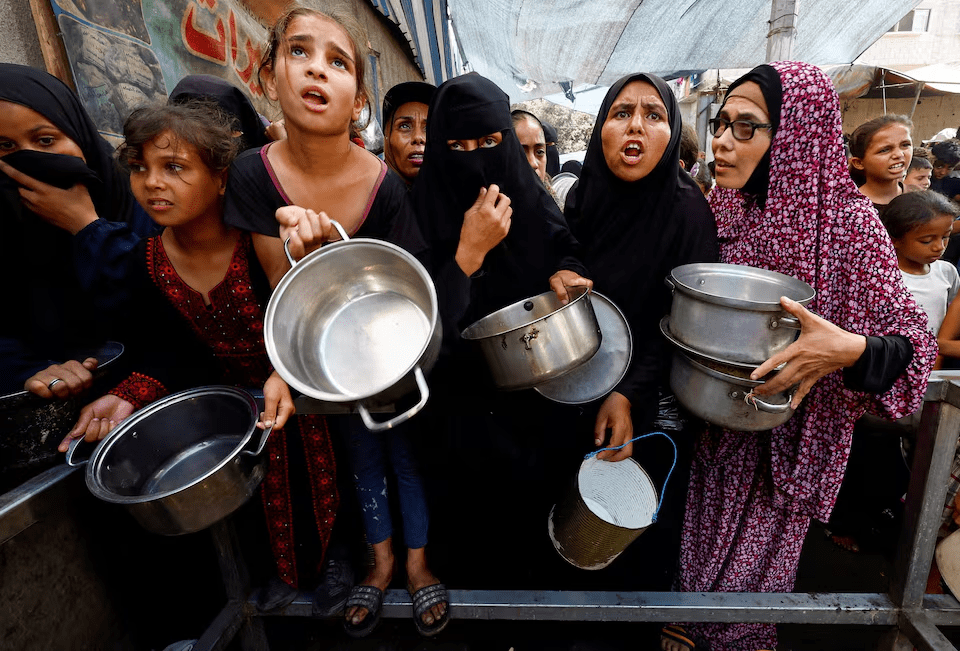 Palestinians gather to receive food from a charity kitchen, in Nuseirat, central Gaza Strip, September 28, 2025. REUTERS/Mahmoud Issa