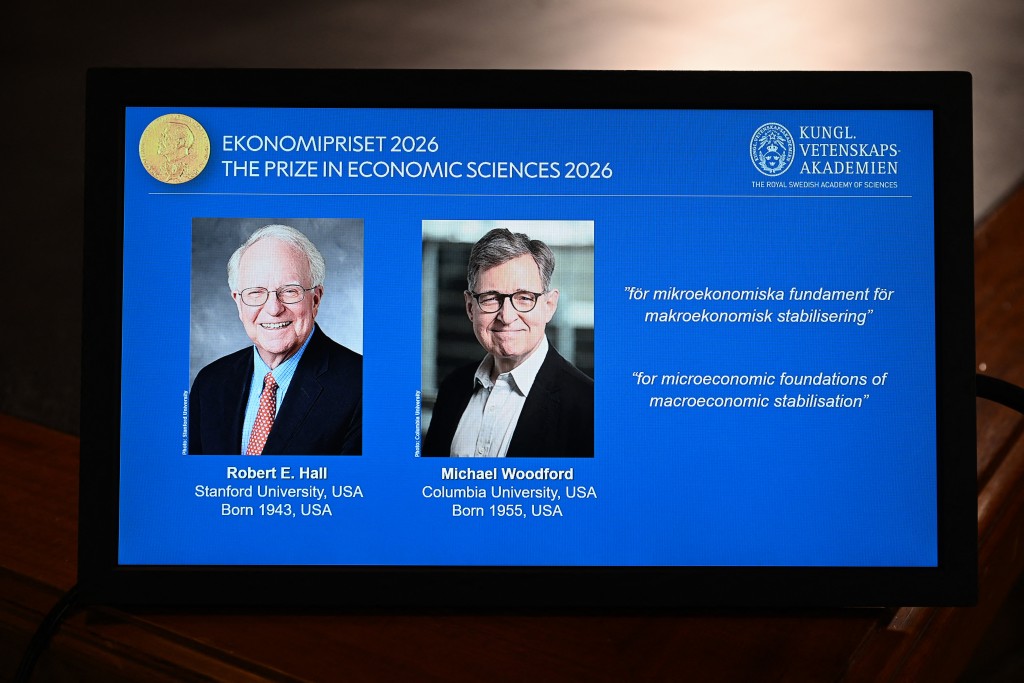 Portraits of laureates US economists Robert E Hall (L) and Michael Woodford are seen on a small screen following the announcement of the winners of the 2026 Sveriges Riksbank Prize in Economic Sciences in Memory of Alfred Nobel at the Royal Swedish Academy of Sciences in Stockholm on October 12, 2026.