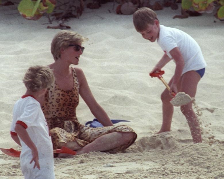 Princess Diana is covered in sand by her son Prince William (R) during a private beach holiday on Necker Island in the British Virgin Islands April 11, 1990. REUTERS/Rob Taggart. 