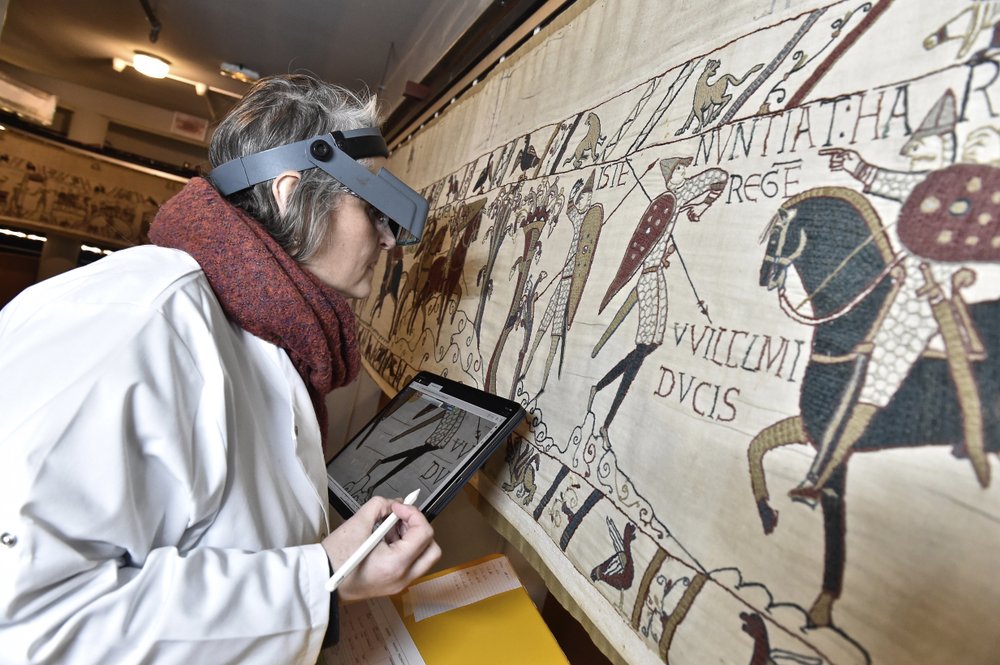 This photo provided by Bayeux townhall shows a technician inspecting the tapestry in Bayeux, Normandy, on January 8, 2020. This photo provided by Bayeux townhall shows a technician inspecting the tapestry in Bayeux, Normandy, on January 8, 2020.