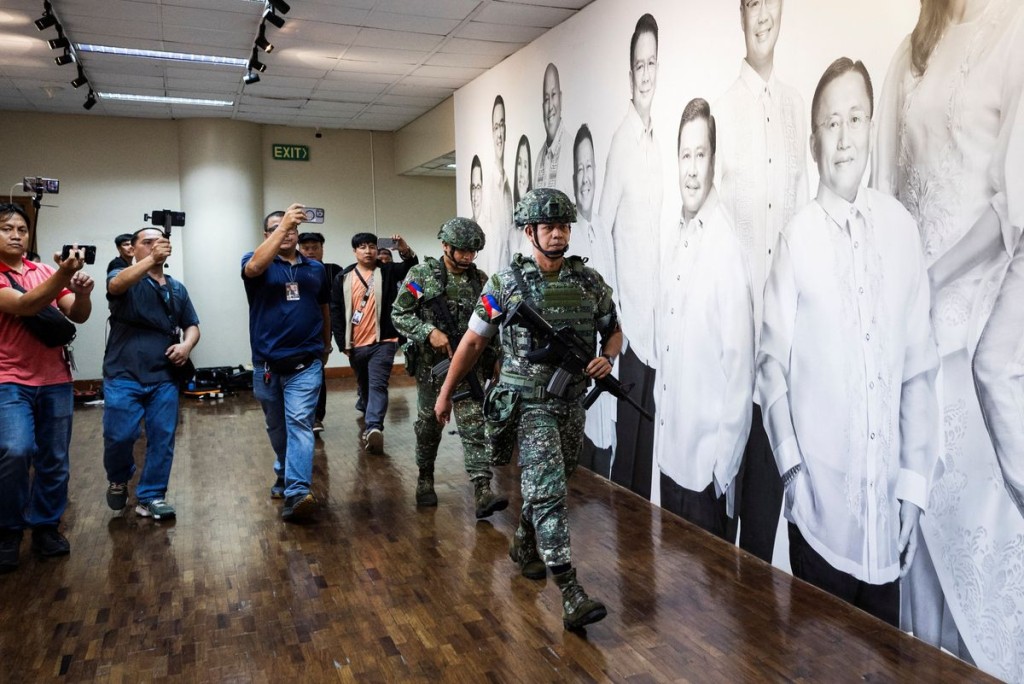 Military personnel in camouflage fatigues enter the Senate building. Reuters
