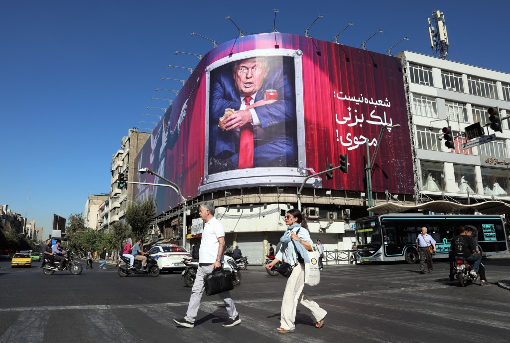 Photo by - / AFP Iranians walk past an anti-Trump billboard along a street in Tehran on September 23, 2026.
