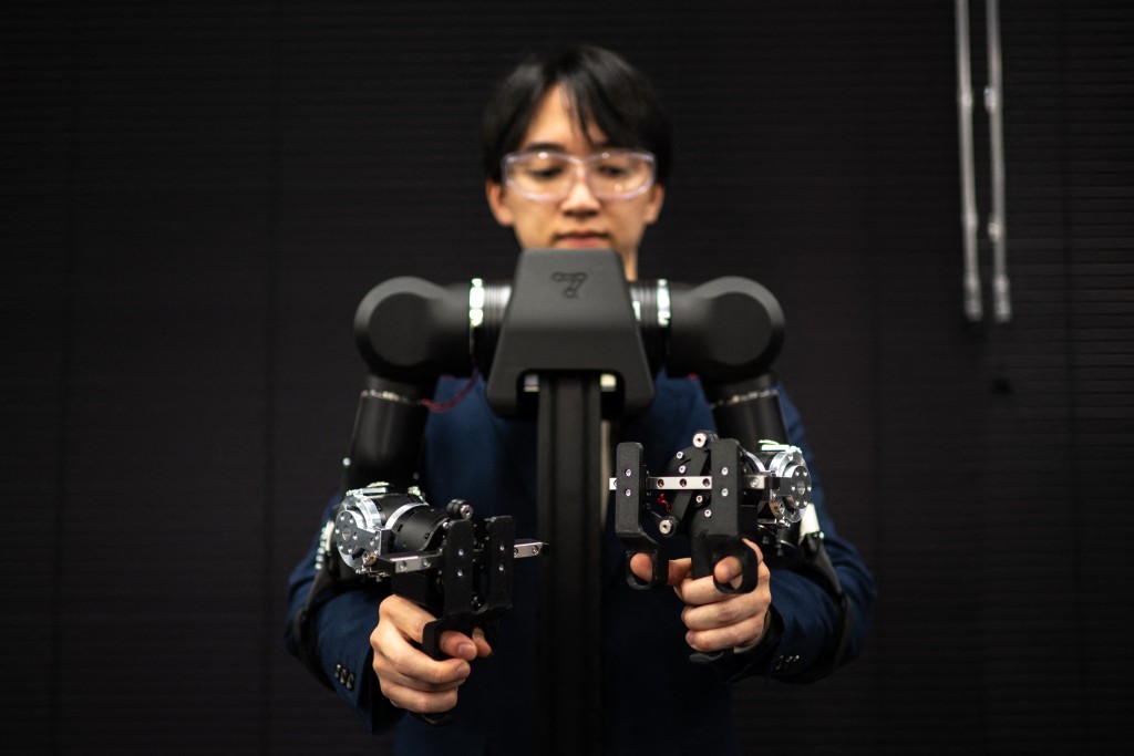 Photo by PHILIP FONG / AFP  This picture taken on November 5, 2025 shows Hiro Yamamoto, CEO of company Enactic, tele-operating an OpenArm humanoid robotic arm at his office during an interview with AFP, in Tokyo.
