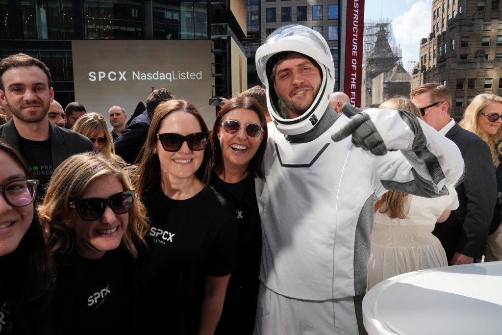 Photo by TIMOTHY A. CLARY / AFP. SpaceX employees cheer after the closing bell at the Nasdaq MarketSite following the launch of SpaceX’s initial public offering (IPO) in New York on June 12, 2026.