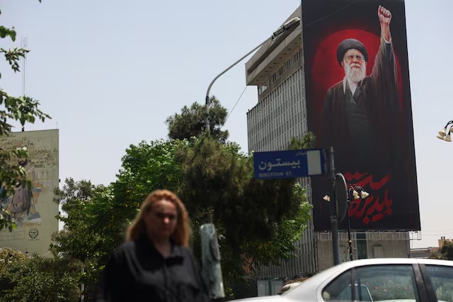 A woman walks by a billboard depicting Iran's late Supreme Leader Ayatollah Ali Khamenei, on a street in Tehran, Iran, July 21, 2026. Majid Asgaripour/WANA (West Asia News Agency) via REUTERS
