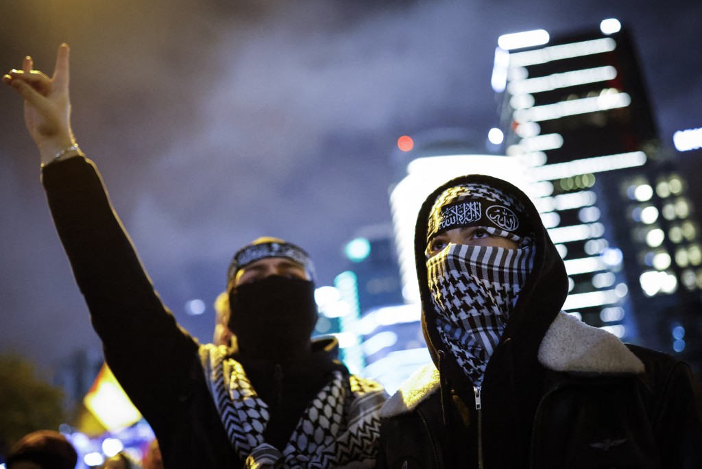 A demonstrator wearing a keffiyeh shows the Wolf Salute sign during a rally in solidarity with Palestinians and to condemn the interception of the Global Sumud Flotilla by Israeli army, in Istanbul on October 2, 2025.  (Photo by KEMAL ASLAN / AFP)