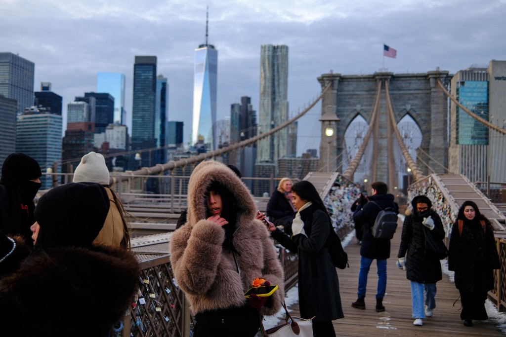 Photo by CHARLY TRIBALLEAU / AFP. People brave the cold temperatures while walking on the Brooklyn Bridge in the Manhattan borough of New York City on January 21, 2026.