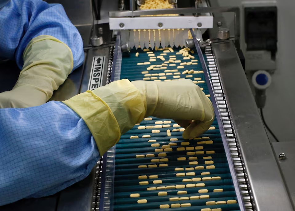 An employee inspects tablets as they move along the production line at a pharmaceutical plant of Lupin, India's No. 2 drugmaker, in Verna, in the western state of Goa, India, June 9, 2017. Picture taken June 9, 2017. REUTERS/Danish Siddiqui/File Photo