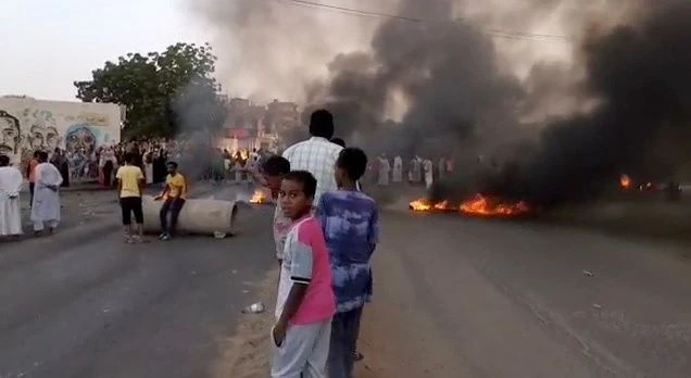 People gather around as smoke and fire are seen on the streets of Kartoum, Sudan, amid reports of a coup, October 25, 2021. People gather around as smoke and fire are seen on the streets of Kartoum, Sudan, amid reports of a coup, October 25, 2021.