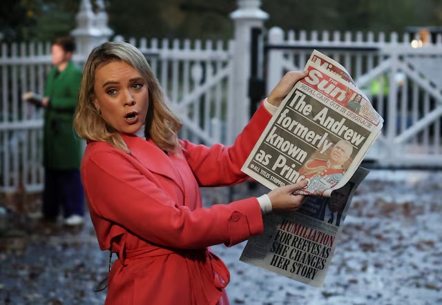 A member of the media shows the front page of a newspaper outside the entrance to the Royal Lodge, a large property on the estate surrounding Windsor Castle, where Andrew, the younger brother of Britain's King Charles lives, in Windsor, Britain, October 31, 2025. REUTERS/Suzanne Plunkett